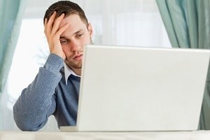 Businessman annoyed by his laptop in his homeoffice